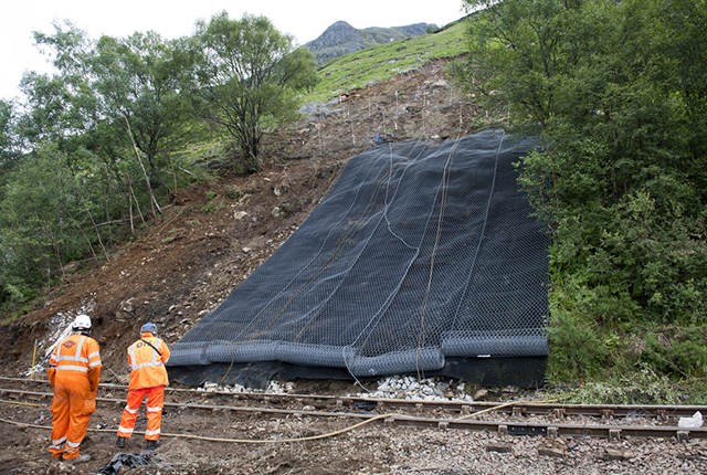 Debris pathway downslope, partly netted. Debris on the railway line has been cleared and the line is in the process of being repaired.